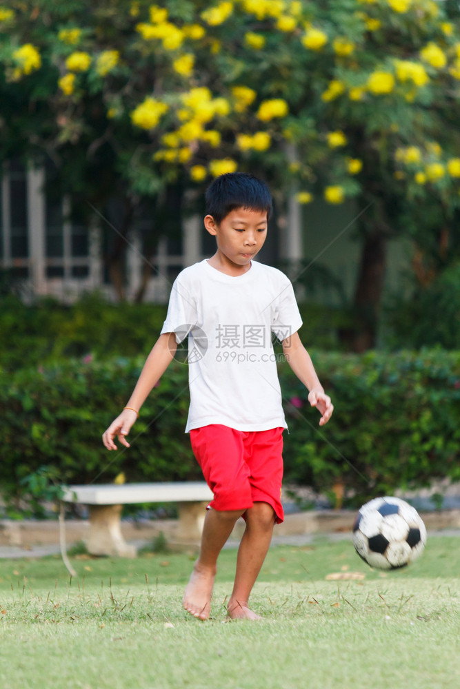 在花园踢足球的泰国男孩白色喜悦场地图片