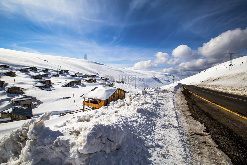 风景山和高地房屋在雪中路爬坡道图片