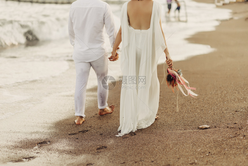 海滩上漫步的新娘新郎图片