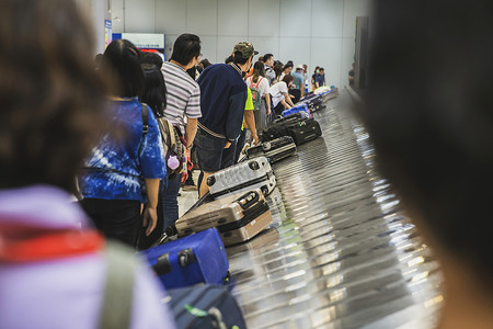 飞手推车站许多乘客在国际机场等待行李箱或携带流动传送的行李这些旅客在机场等候旅行年轻的高清图片素材