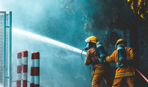 林业黑暗的危险消防员向野火喷洒水图片