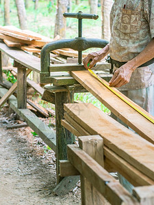 仪表工作夹住Carpenter测量花园中用旧金属压缩工具固定板的长度图片