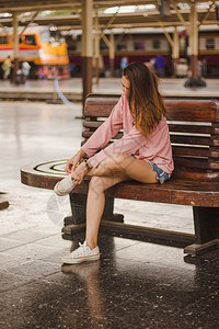 坐在长木椅上的女人制长椅白色图片