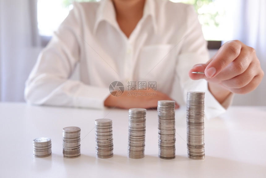 商业界人士将硬币放置在增加的硬币堆叠上成功公司的通货膨胀图片