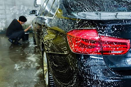 打蜡用泡肥皂洗黑车辆泡沫背景图片