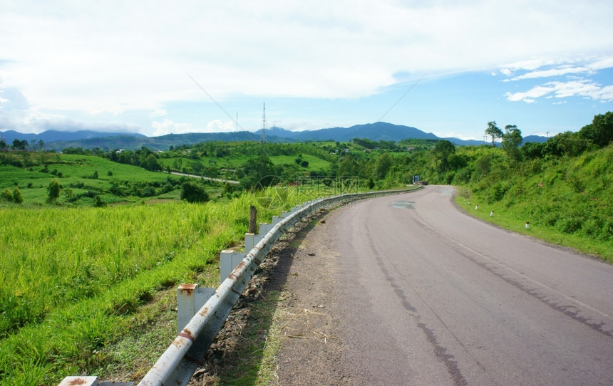 蓝色的天空越南乡村公路横越沙丘丛林或山旅行路线发现Vetianam白天蓝下农村地貌孤图片