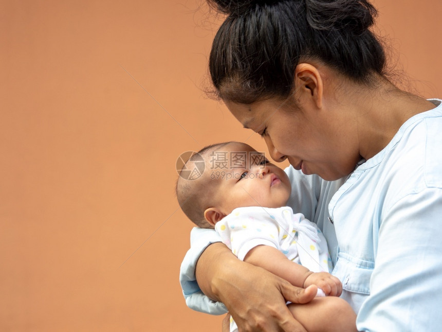 快乐的亚洲母亲肖像抱着他新生的甜蜜婴儿打扮着妈带她的孩子用爱和照顾她的女儿当她被抱着时总是幸福快乐脸人们男图片