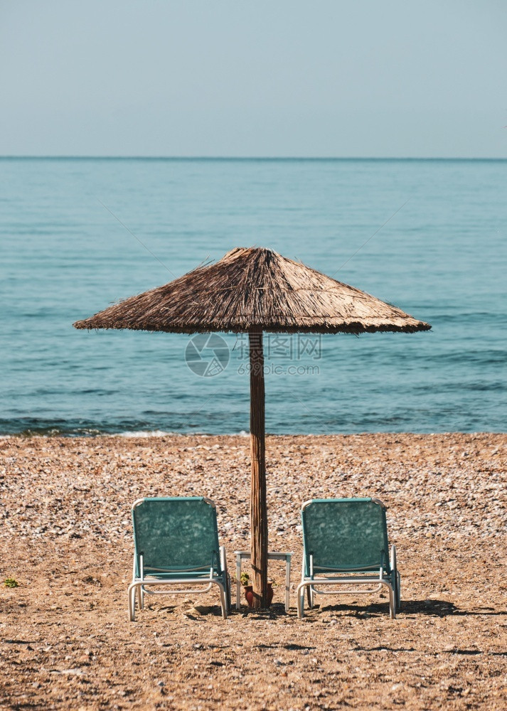 Reed海滩雨伞沙上带防晒霜放松旅游的宁静图片