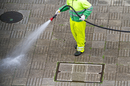 持水管的工人在行道上打扫清水城市维护或清洁概念一种劳动最佳图片