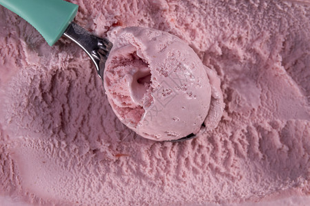 可口盒子草莓味冰淇淋的顶端视图盒里有勺子浆果背景图片