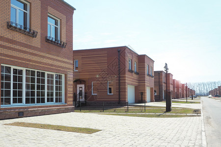 锻造财产两级层住宅楼公寓和个别车库分入口和单个车库由红砖黄和棕制成的水泥建造厂房背景图片
