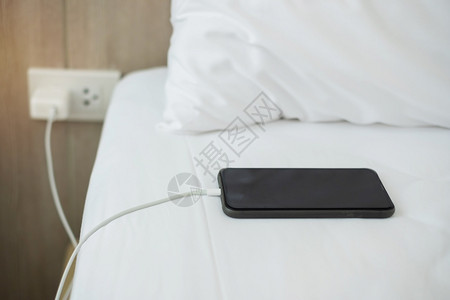 充值返现药片沟通在家里卧室的床上用手机智能充电池技术多种分享和生活方式概念在家庭卧室的床上使用多式共享和生活方概念展示背景
