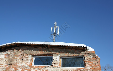 全球的旧房子屋顶上空中移动通信对抗蓝天的色空电话老的图片