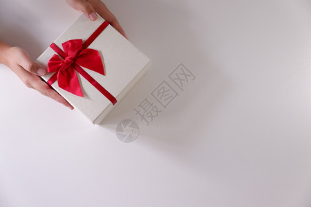 周年纪念日女孩近身妇手送白礼盒色带红丝和背景女图片