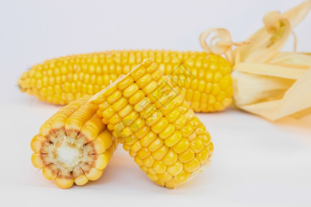 边缘将白色背景的玉米片切成半芯食物图片