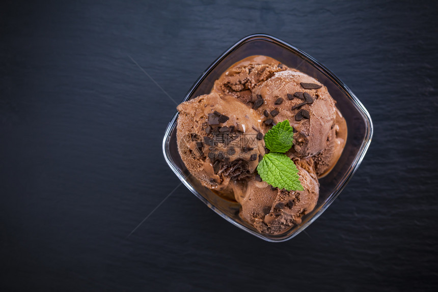 冷冻甜点碗加勺子巧克力冰淇淋在石板背景上杯子里的巧克力冰淇淋茶点图片