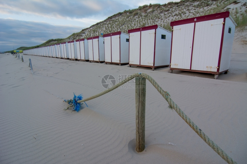 鹅卵石荷兰海滩的沙小屋英国晴天图片