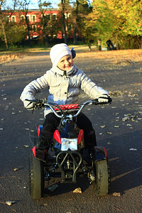 微笑树叶小女孩驾驶电动玩具车的表达方式满足了自己心意的小女孩驾驶电动玩具车的呼声青少年秋天高清图片素材