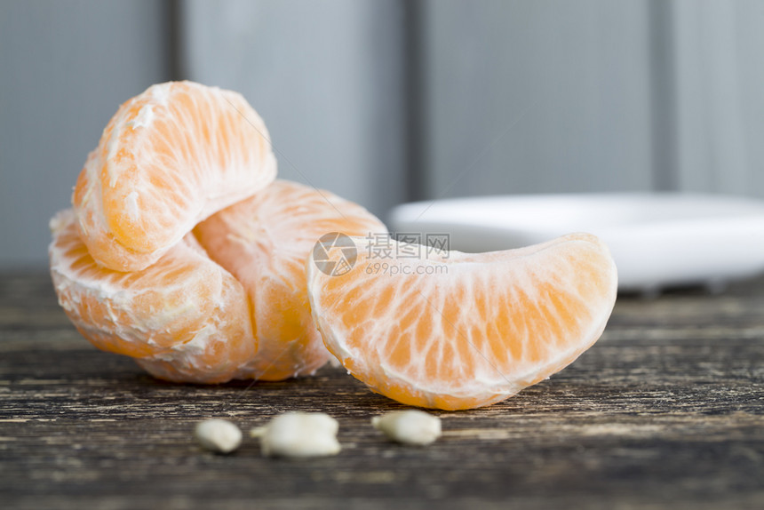 底有木墙和一碗白熟的柑橘还有被吃掉的橘子骨骼烧熟的红橘子美味有机白色图片