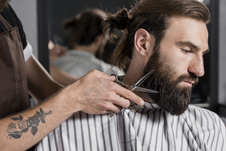 剪男客户胡子的美发店裁缝理师白种人剃须工作理发店高清图片素材