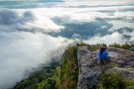 薄雾女士山坐在悬崖边的快乐女人图片