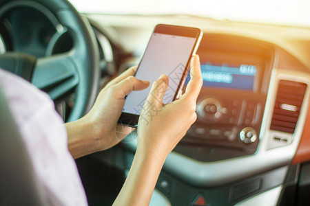 沟通女亚裔妇在路上驾驶汽车使用智能手机在路上微笑亚洲人高清图片素材