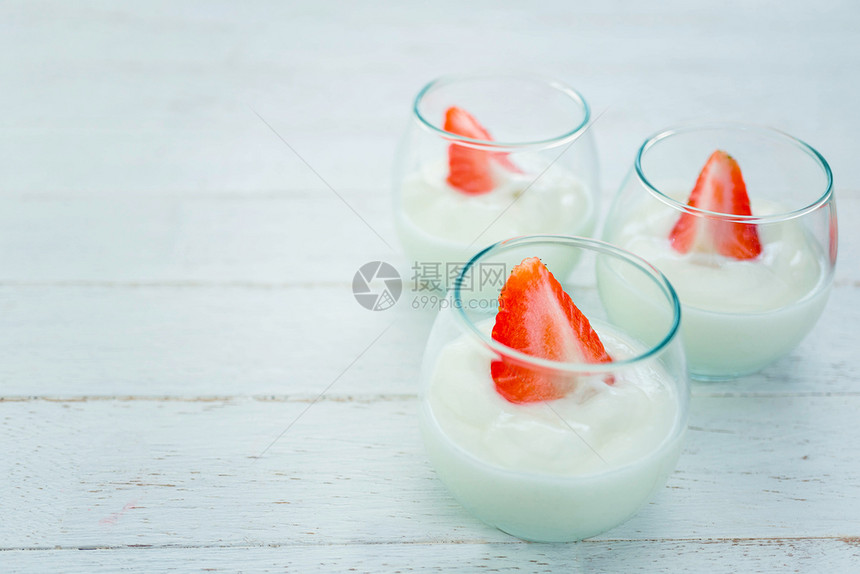 希腊语食物奶油的原味酸在白木背景上用清玻璃的新鲜草莓图片