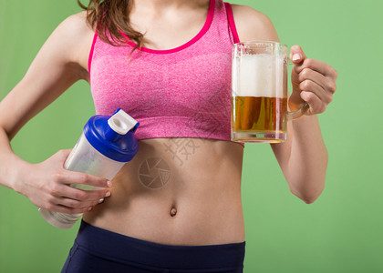 力量成人女孩在啤酒杯和蛋白奶昔瓶子之间做出抉择强的图片