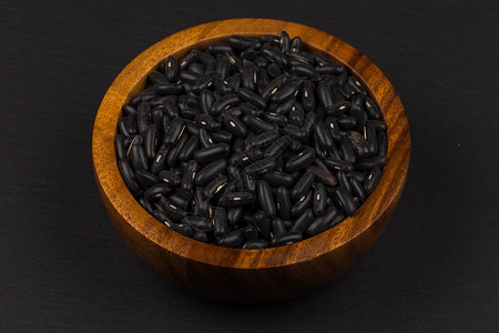 干燥深黑背景木碗中的眼豆堆积的食物图片