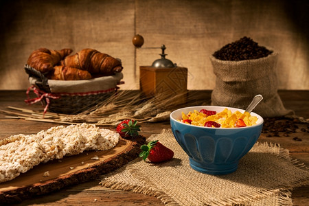 木制的蓝色头欧陆式早餐包括玉米片和草莓一杯牛奶和米果放在一张旧木桌上欧式早餐玉米片和草莓背景