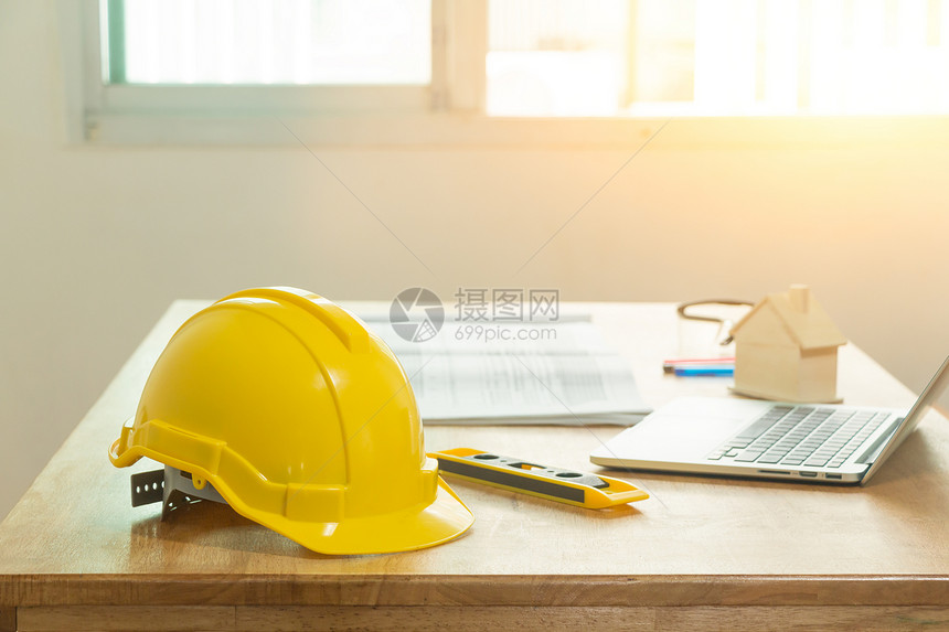 正面帽子黄色头盔在工程师办公桌上技术人员的安全头盔是工程师或建筑人学图片