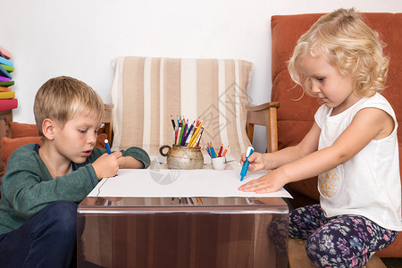 男女儿童在家中有创造时间的纸张上画快乐的学习桌子乐趣高清图片素材