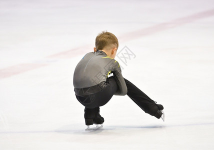 男孩式滑冰在带人工的滑场上刀积极的冷若冰霜图片