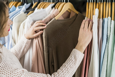 高兴的商品妇女在购物服装期间选择着的妇女消费者商业高清图片素材