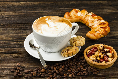 艺术黑背景上的蛋糕和卡布普西诺咖啡杯包子早餐背景图片