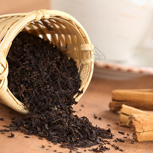 输液器棍子使用肉桂棒和茶杯的木制叶中松露黑以肉桂棒和杯来突出重点在茶叶的边缘集中关注茶叶自然背景图片