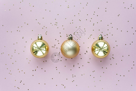 金色圣诞球装饰闪发光粉彩现代的金色圣诞球和柔粉色背景上的星顶视图金色圣诞球和柔粉色背景上的星圣诞闪光组合物背景