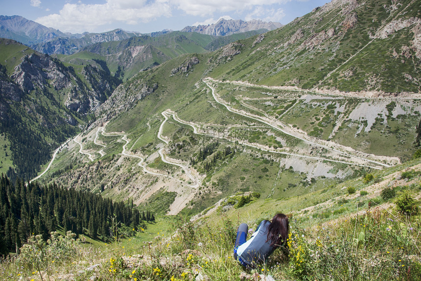 岩石山天的蛇纹高速公路山谷地貌惊人前面有坐着女孩的美丽场景图片