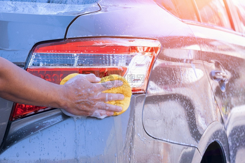 车辆男人近身手用海绵和泡沫来洗尾光从侧面看现代车蓝色的图片