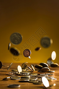 木桌背景上的银金币和落木制背景上的银金币和落交换成功雨图片