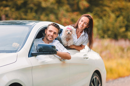 狗和车女士景观孩两个年轻人享受暑假快乐的情侣观光客从汽车上寻找年轻夫妇游客在暑假期间享受旅游背景