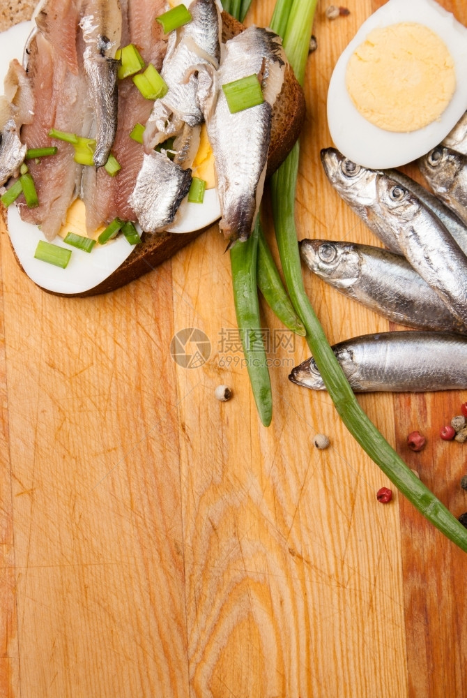 以含蛋的咸鱼和木头上春天洋葱为原料渔业美味佳肴饲料图片