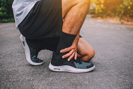 赛跑者痛苦步脚踝受伤在街上奔跑的男子正在去锻练运动背景捻运动的高清图片素材