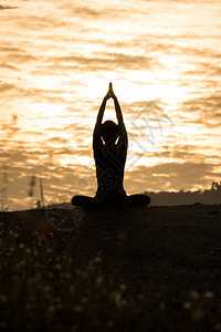 练习日落时在山上做瑜伽的年轻女子关心淑图片