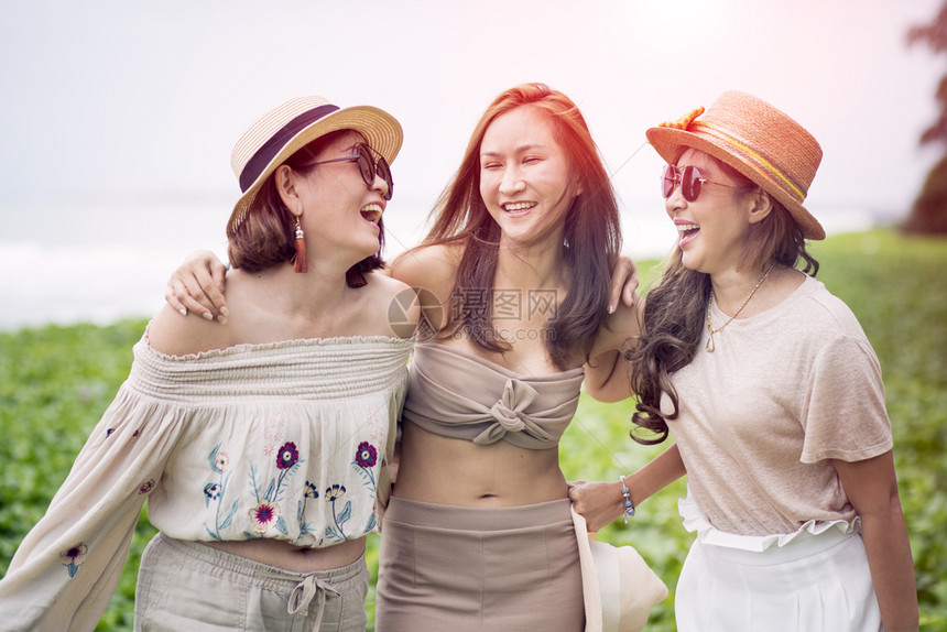 闲暇朋友们在度假海滨滩上三个欢快的亚洲女幸福情绪快乐的图片
