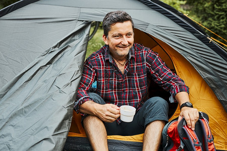 咖啡帐篷暑假期间在露营帐篷中放松的男子背景