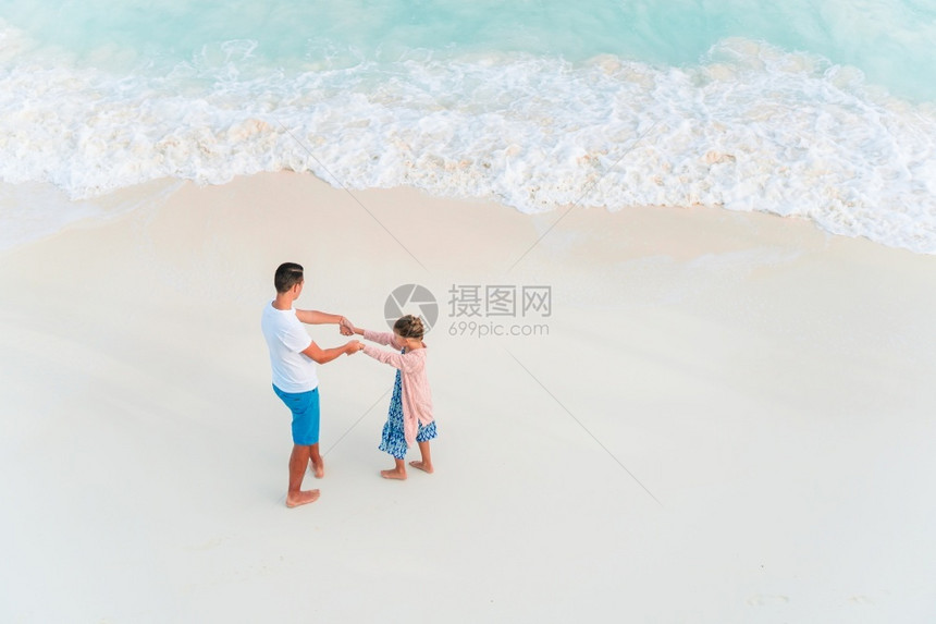 海滩水白沙上快乐的父亲和小女孩在沙滩度假期间快乐的爸和小女儿一起欢乐吧异国情调图片