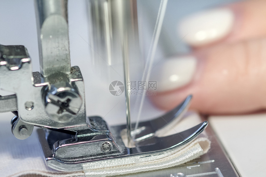 剪裁白色的缝纫机和针穿线缝纫机特写材料图片