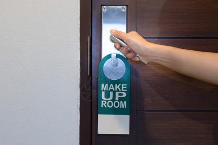 入口锁松弛手握着门把和上贴标签的门把手在旅馆里装房间警告高清图片素材
