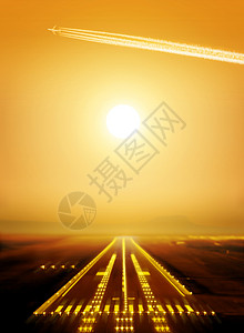 日落时客机在场跑道上空飞行高清图片